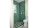 Updated bathroom featuring a window in green tiled shower with black mosaic tiled floor at 2524 Glenrock Dr, Decatur, GA 30032