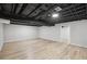 Finished basement area with painted ceiling and light-colored wood-look flooring throughout at 5414 Iris Sw Dr, Mableton, GA 30126