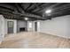Finished basement room with light-colored walls, wood-look floors and painted brick fireplace at 5414 Iris Sw Dr, Mableton, GA 30126