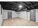 Large finished basement area with light wood flooring and open ceiling design at 5414 Iris Sw Dr, Mableton, GA 30126