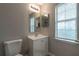Well-lit bathroom featuring a vanity with storage and window at 5618 Stonington Trace Pkwy, Stone Mountain, GA 30087