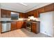 Well-lit kitchen with stainless steel appliances, tile flooring, and abundant wood cabinets for ample storage at 5618 Stonington Trace Pkwy, Stone Mountain, GA 30087