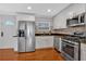 Modern kitchen featuring stainless steel appliances, white cabinets, backsplash, and hardwood floors at 1261 Lavista Ne Rd # E-8, Atlanta, GA 30324