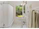Bright bathroom with pedestal sink, shower and window with views of the landscaped yard at 1036 Oxford Ne Rd, Atlanta, GA 30306