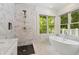 This bathroom features a marble walk-in shower, soaking tub, and large window at 1036 Oxford Ne Rd, Atlanta, GA 30306