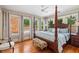Spacious main bedroom featuring hardwood floors, four-poster bed and multiple windows at 1036 Oxford Ne Rd, Atlanta, GA 30306