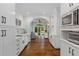 Spacious white kitchen with stainless appliances, marble counters, and arched brick doorway to the sunroom at 1036 Oxford Ne Rd, Atlanta, GA 30306