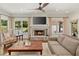 Comfortable living room with stone fireplace, ceiling fan, hardwood floors, and large windows offering backyard views at 1036 Oxford Ne Rd, Atlanta, GA 30306