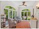 Bright sunroom with brick floors, sitting area, arched windows and views of the landscaped yard at 1036 Oxford Ne Rd, Atlanta, GA 30306