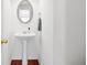 Bathroom featuring a stylish pedestal sink and oval mirror at 125 Flatwood Trail, Marietta, GA 30066