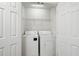 Compact laundry room featuring a washer, dryer, and wire shelving for efficient organization at 125 Flatwood Trail, Marietta, GA 30066
