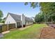 Spacious backyard with a patio, wooden fence, lush green grass, and mature trees providing shade and privacy at 192 Sandhurst Ct, Suwanee, GA 30024
