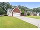 Spacious front yard showcasing a brick home with an attached garage and manicured landscaping at 192 Sandhurst Ct, Suwanee, GA 30024