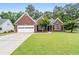 Charming brick home with a well-manicured lawn, attached garage, and inviting front entrance at 192 Sandhurst Ct, Suwanee, GA 30024