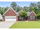 Charming brick home with a well-manicured lawn, attached garage, and inviting front entrance at 192 Sandhurst Ct, Suwanee, GA 30024
