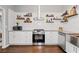 Bright kitchen featuring white cabinetry, stainless appliances, and open shelving for decor at 192 Sandhurst Ct, Suwanee, GA 30024