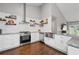 Stylish kitchen featuring stainless steel appliances, granite counters, and decorative floating shelves at 192 Sandhurst Ct, Suwanee, GA 30024