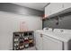Functional laundry room featuring shelving for storage and modern washer and dryer units at 192 Sandhurst Ct, Suwanee, GA 30024
