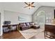 Comfortable living room featuring a leather couch, hardwood floors, and natural light from a large window at 192 Sandhurst Ct, Suwanee, GA 30024