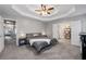 Relaxing main bedroom boasting a tray ceiling, carpeting, and access to the en-suite bathroom at 192 Sandhurst Ct, Suwanee, GA 30024