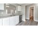 Modern kitchen with white cabinets, granite counters, stainless steel appliances, and wood-look floors at 2022 Patterson Park Dr, Lawrenceville, GA 30044