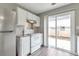 Bright kitchen with stainless steel refrigerator, white appliances, granite counters, and sliding glass door at 2022 Patterson Park Dr, Lawrenceville, GA 30044