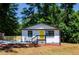 Charming home featuring a bright yellow door and freshly painted white brick, surrounded by lush greenery at 4244 Lindsey Dr, Decatur, GA 30035