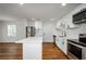 Spacious kitchen with stainless appliances, island, white cabinetry, and wood-look flooring, seamlessly connected to living areas at 4244 Lindsey Dr, Decatur, GA 30035