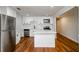 Modern kitchen featuring white cabinets, stainless steel appliances, and a sleek island, complemented by hardwood floors at 4244 Lindsey Dr, Decatur, GA 30035