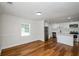 Open-concept living space with a modern kitchen boasting white cabinets, stainless steel appliances, and hardwood floors at 4244 Lindsey Dr, Decatur, GA 30035
