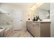 Bathroom with a tub, granite countertop, gray cabinets, decorative fixtures, and marble floor at 4327 Azalea Ridge Way, Hoschton, GA 30548