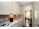 Convenient butler's pantry with ample countertop space, cabinetry, and stylish backsplash adjacent to dining room at 4327 Azalea Ridge Way, Hoschton, GA 30548
