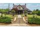 Beautifully landscaped home with a stone staircase leading to the front porch and door at 4327 Azalea Ridge Way, Hoschton, GA 30548