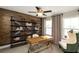 Home office with wooden accent wall, built-in shelving, and natural light at 4327 Azalea Ridge Way, Hoschton, GA 30548