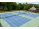 Aerial view of community tennis courts surrounded by lush greenery; attractive gazebo nearby at 4327 Azalea Ridge Way, Hoschton, GA 30548