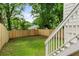 Green fenced backyard with a stairway leading up the side of the house at 995 Lena Nw St, Atlanta, GA 30314