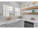 Bright kitchen featuring a farmhouse sink, white cabinets, quartz countertop, and wood floating shelves at 995 Lena Nw St, Atlanta, GA 30314