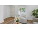 Bright living room with hardwood floors, stylish chair and view of front porch through window at 995 Lena Nw St, Atlanta, GA 30314