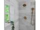 Elegant marble shower with a rain shower head, handheld sprayer, and a window for natural light at 995 Lena Nw St, Atlanta, GA 30314