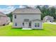 View of the backyard with a green lawn and grey siding on the house at 2090 Harvester Ln, Buford, GA 30518