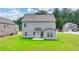 View of the backyard with a green lawn and grey siding on the house at 2090 Harvester Ln, Buford, GA 30518
