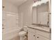 Bathroom features tub with shower, single vanity, granite counter and modern fixtures at 2090 Harvester Ln, Buford, GA 30518