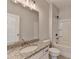 Well-lit bathroom with granite countertop, framed mirror, and shower-tub combination at 2090 Harvester Ln, Buford, GA 30518