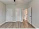 Bedroom boasts three doors, ceiling fan, modern lighting, and wood flooring at 2090 Harvester Ln, Buford, GA 30518