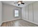 Bedroom features gray walls, ceiling fan, modern lighting, and wood flooring at 2090 Harvester Ln, Buford, GA 30518