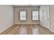 A bright bedroom is lit with natural light from two windows and features wood-look floors at 2090 Harvester Ln, Buford, GA 30518