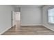 Bedroom featuring wood-look floors, light grey walls, and access to another room at 2090 Harvester Ln, Buford, GA 30518