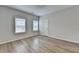 A bright bedroom is lit with natural light from two windows and features wood-look floors at 2090 Harvester Ln, Buford, GA 30518