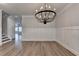 Elegant dining room with a modern chandelier, stylish wainscoting, and wood-look floors at 2090 Harvester Ln, Buford, GA 30518