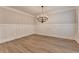 Bright dining room features elegant wainscoting, modern lighting and hardwood flooring at 2090 Harvester Ln, Buford, GA 30518